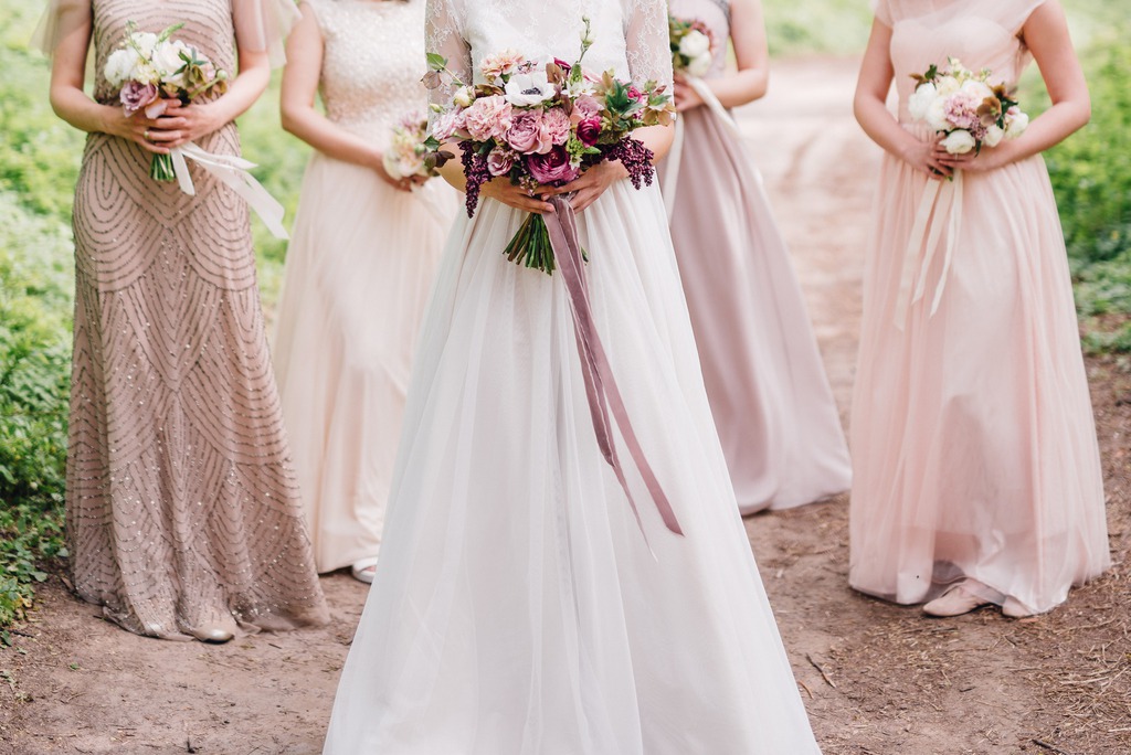 bride and bridesmaid are holding bouquets of flowers in hands.jpg